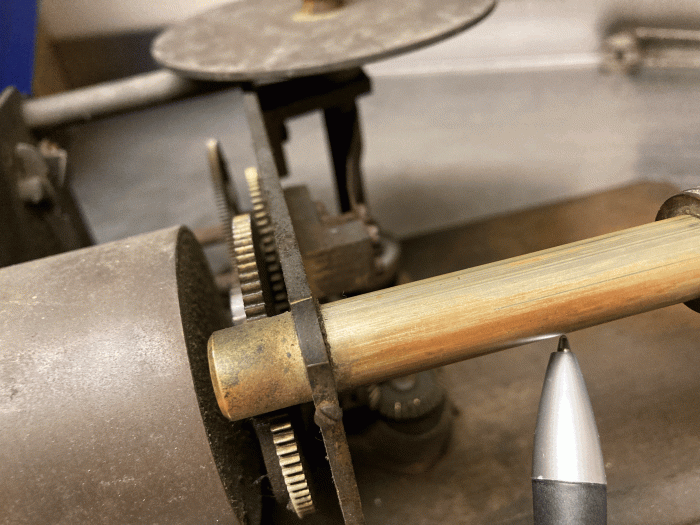 The feedscrew that moves the carriage is inside this tube and is similar to the method used in Columbia cylinder machines.