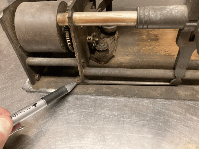 There is an arm connected to the very bottom of the carriage.  As the carriage moves the arm is connected to the governor.