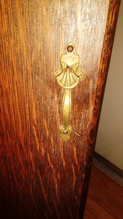 View close up of door latch and seashell detailing.